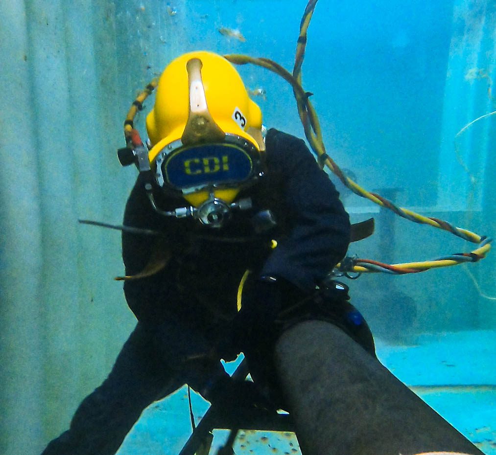 A Person Wearing a Helmet and a Helmet Underwater